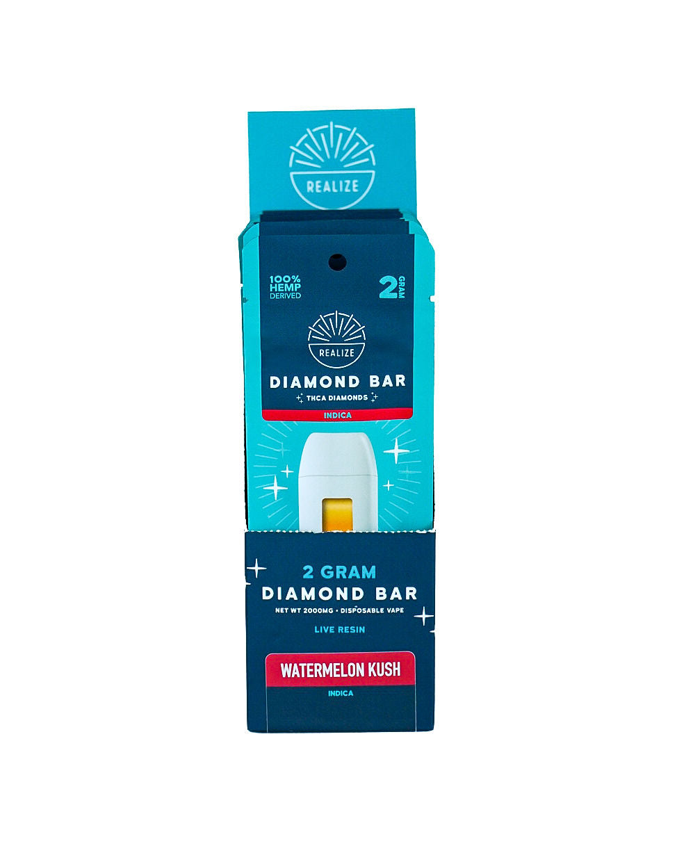 Realize Hemp Diamond Bar disposable vape packaging in Watermelon Kush (Indica). The image features a turquoise and navy-blue retail box partially opened to reveal a white vape device with visible amber oil. Packaging displays the Realize logo and product details including "2 Gram Diamond Bar," "THCa Diamonds," "Live Resin," and "100% Hemp Derived." The Watermelon Kush strain is highlighted on a red label, with Indica designation shown on the packaging. Product photographed against a light gray bac